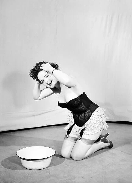 Woman wearing corsett washing hair. 1959