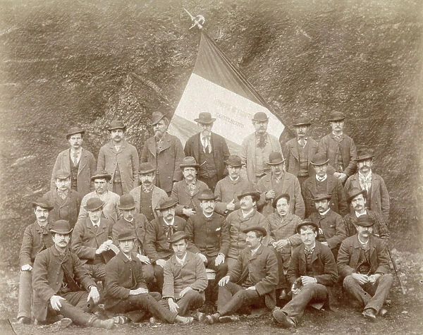 Group of workers in a lignite mine in Castelnuovo. They are wearing civilian clothing. Behind them an italian flag can be seen