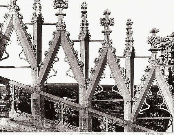 Detail of a rampant arch of the Cathedral of Milan. The panorama of the town is visible through the perforations
