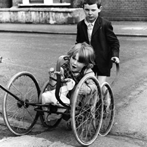 Girl and boy with pram wheels, Balham, SW London