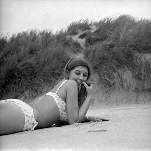 Model on a beach near sand dunes