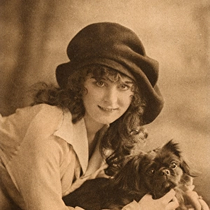 Studio portrait, young woman with Pekingese dog