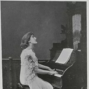 Woman seated at keyboard of a pipe organ, studio portrait