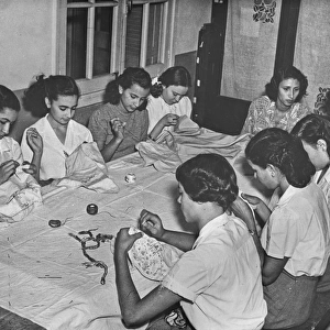 Women sitting at a table sewing