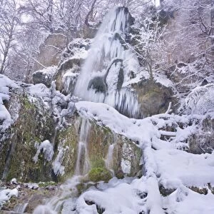 Frozen Waterfall - a waterfall in winter with numerous icicles and snow and ice covered rocks, branches and trees - Swabian Alb - Baden-Wuerttemberg - Germany