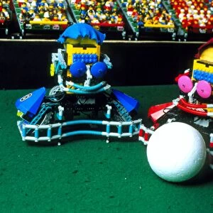 Two Lego footballers with a ball at RoboCup-98