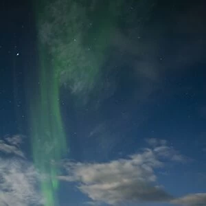 Aurora borealis over lake with boats and Kota, Kilpisjarvi, Northwest Finland, Lapland
