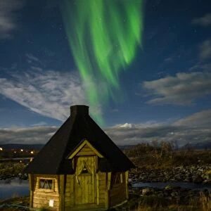Aurora borealis over lakeside Kota (hut), Kilpisjarvi, Northwest Finland, Lapland