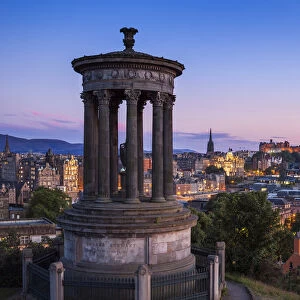 Dugald Stewart Monument, city centre and Edinburgh skyline at sunset, Calton Hill