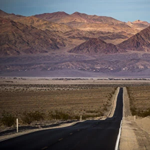 Highway through Death Valley with mountains in the distance, California, United States of America