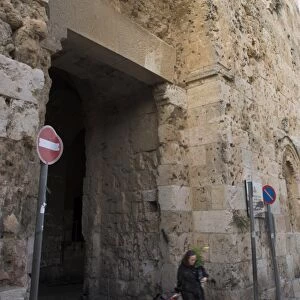 Woman walking out of old city through Zion Gate