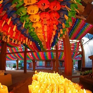 Rainbow coloured paper lanterns and candles at an altar in Bongeunsa Temple in Seoul