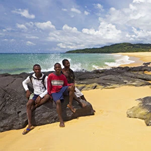 Africa, Sierra Leone, Freetown Peninsula, John Obey Beach. Boys sitting on rocks