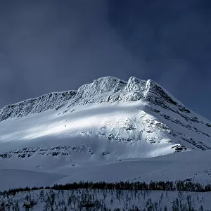 Dramatic sky over majestic mountain peak covered with snow, Lyngen Alps, Tromso, Troms og Finnmark, Norway