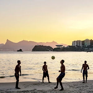 People playing football on Icarai Beach at sunset, Niteroi, State of Rio de Janeiro