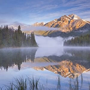 Pyramid Mountain reflected in Pyramid Lake at dawn on a misty morning, Jasper National Park