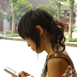 CHINA, Sichuan Province, Chongqing Girl using a mobile phone