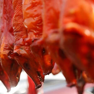 Grilled pigs are seen for sale along a street during Chinese Lunar New Year