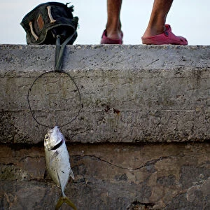People fish at the seafront in Havana