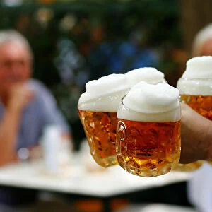 A waiter serves beer in the traditional Schweizerhaus beer garden in Vienna