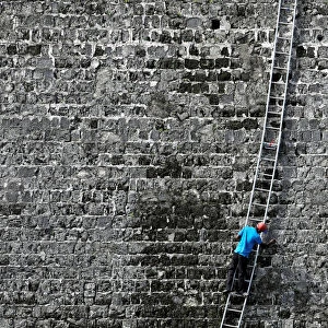 A worker cleans a wall at the Jaffna Fort, a fort built by the Portuguese in 1618