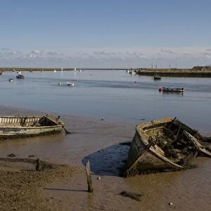 Abandoned boats on the mud flats of the River Ore near Orford, Suffolk. Orford ness on the right