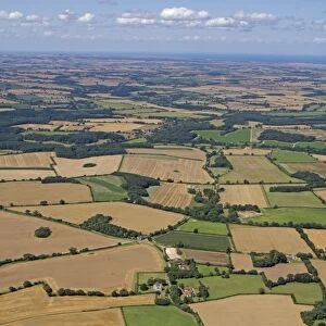 Aerial view of farmland with arable fields, hedgerows and woodland, North Norfolk, England, August