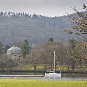 Boat sailing on lake beside island with 18th Century building, The Roundhouse, Belle Isle, Lake Windermere