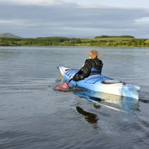 Boy kayaking on reservoir, Killington Lake, Killington Beck, Cumbria, England, June Boy kayaking on reservoir, Killington Lake, Killington Beck, Cumbria, England, June