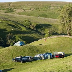 Campsite with campervans and tents on farmland in evening, Swaledale, Yorkshire Dales N. P