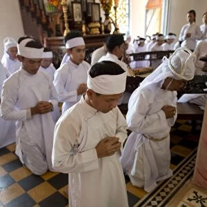 Caodaist disciples kneeling during ceremony, Cao Dai temple, Tay Ninh Holy See, Tay Ninh, Tay Ninh Province, Vietnam