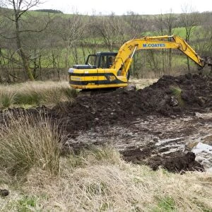 Contractor with 360degree excavator, digging wildlife pond on farm, Powys, Wales, April