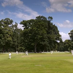 Cricket match being played on village pitch, on summer afternoon, England, July