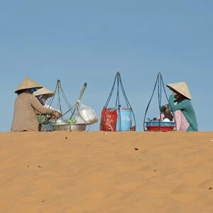 Drink sellers in conical hats, sitting on coastal sand dunes, Phan Thiet, Binh Thuan Province, Vietnam, December
