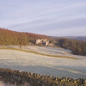 Drystone wall and frosted grasses, with remains of 15th Century hunting lodge in distance, Barden Tower, Barden