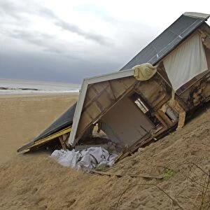 Eroded sea cliffs and damaged chalet after December 2013 tidal surge, Hemsby, Norfolk, England, January