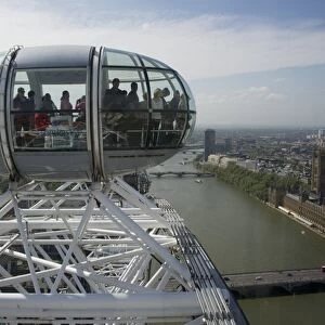 Ferris wheel passenger capsules overlooking city river, London Eye, South Bank, River Thames, Lambeth, London, England