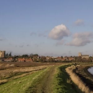 Footpath on the sea wall looking over the village of Orford with its Norman castle and church, Suffolk