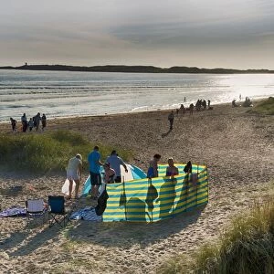 Holidaymakers and windbreak on beach, Newborough, Anglesey, Wales, August
