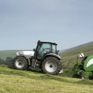 Hurlimann tractor with McHale round baler, baling on steep upland meadow, Cumbria, England, July Hurlimann tractor with McHale round baler, baling on steep upland meadow, Cumbria, England, July