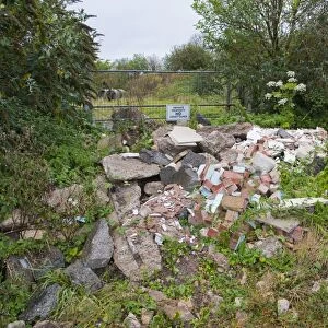 Illegal flytipping of building rubble in front of farm gateway with Private Property, No Admittance sign