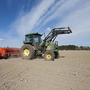 John Deere 2140 tractor with Tume seed drill, sowing arable crop in dusty field, Sweden, may