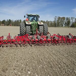 John Deere 7720 tractor with Vaderstad NZ-Aggressive-800 harrows, harrowing arable field, Sweden, may