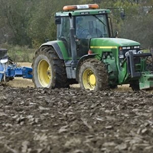 John Deere 8400 tractor pulling eight furrow reversible plough, ploughing stubble field, Sweden, autumn