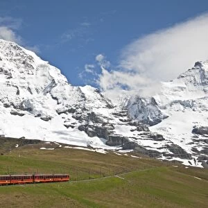 Jungfraubahn train leaving Kleine Scheidegg towards Jungfraujoch, Monch mountain in background, Bernese Alps