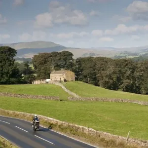 Motorcyclists on rural road speeding and doing wheelie, Hawes, Wensleydale, Yorkshire Dales N. P Motorcyclists on rural road speeding and doing wheelie, Hawes, Wensleydale, Yorkshire Dales N. P