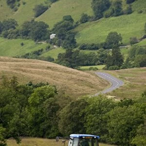 New Holland TM155 tractor with McHale f550 round baler, big baling for silage on upland meadow, England, july
