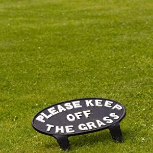 Please Keep Off The Grass cast iron sign on lawn, Dyfed, Wales, July
