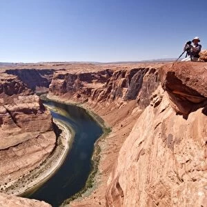 Photogarpher at the Horseshoe bend overlook, the Colorado River in Glen Canyon is making a 270 curve in an entrenched