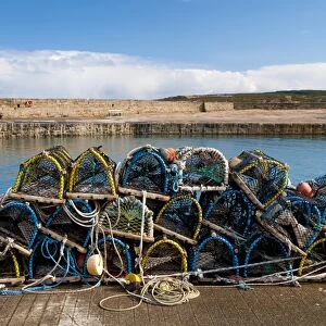 Pile of lobster pots stacked on quayside, Hopeman Harbour, Morayshire, Scotland, March